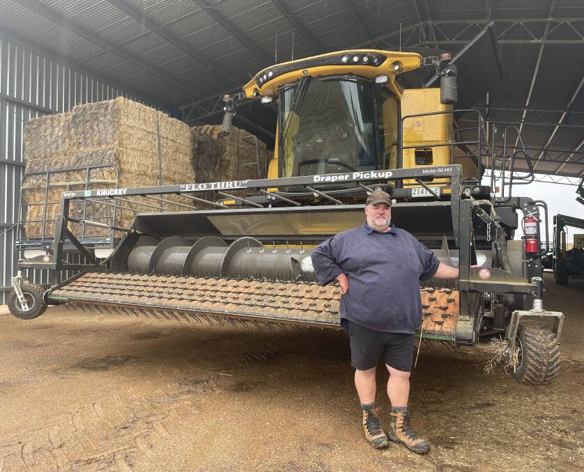 WAITING FOR SUN: Farmer Daniel Mickan with his header in the shed, out of the way of the heavy rainfall until harvest operations can restart. Picture: VICTORIA ELLIS