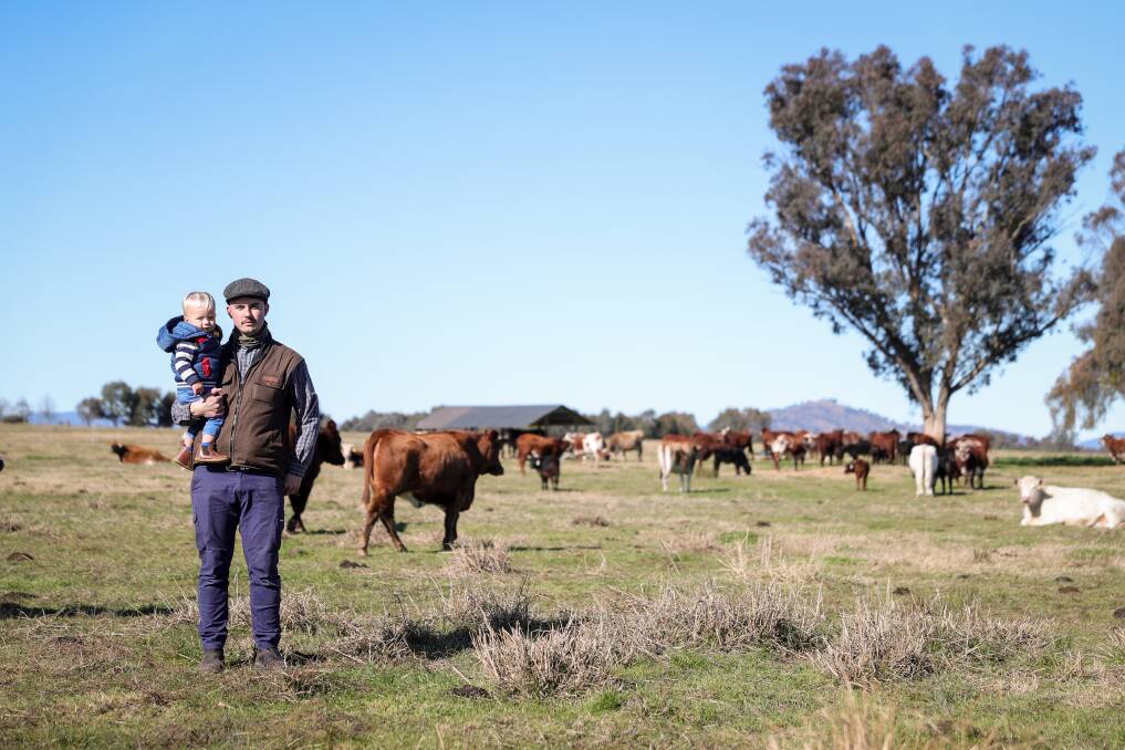 CONCERNED Wolki farm owner Jacob Wolki with his son Theodore, 20 months, on their farm near Thurgoona. Picture: JAMES WILTSHIRE