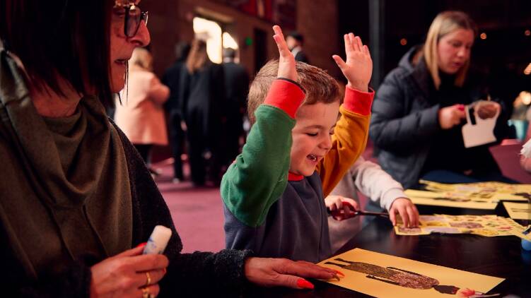 A child celebrates their artwork at a making workshop at National Gallery of Victoria International, Melbourne. Picture by Eugene Hyland