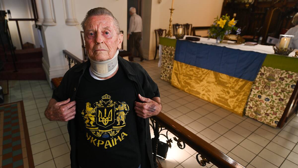 PROUD: Thurgoona resident and Ukraine refugee George Dosenko, 90, in front of the Ukraine flag.