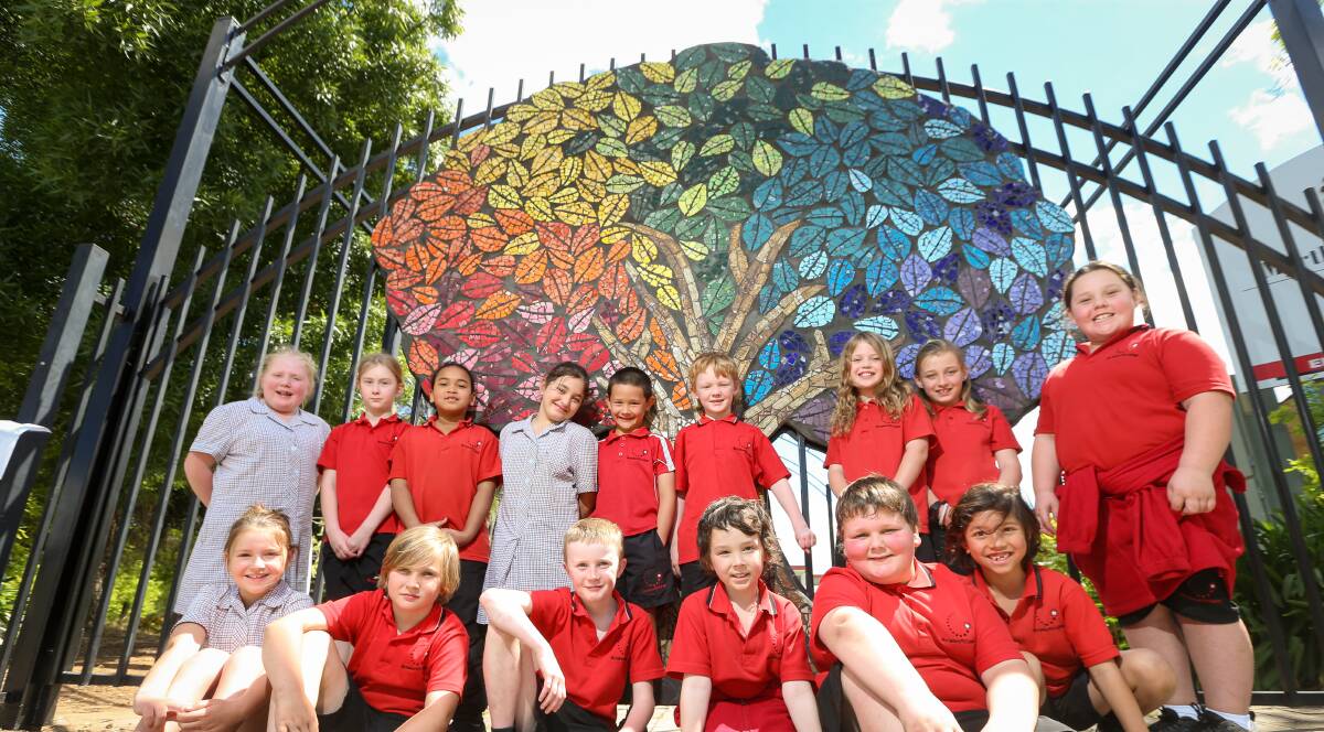 CREATIVE KIDS: School children at Myrtleford P-12 school have worked with two local artists to create a mosaic tree on the school gates, as part of project by Regional Arts Victoria. Picture: JAMES WILTSHIRE