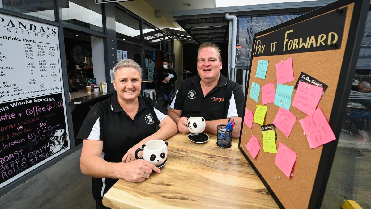 SMILING FACES: Panda's Kitchen manager Susan Hayes and owner Dean West next to the cafe's pay it forward and positivity pin board in Thurgoona Plaza. Pictures: MARK JESSER