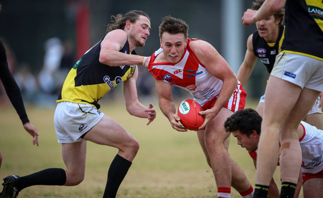 HANDS ON: Henty's Fletcher Macreadie looks to keep Henty moving but Connor Galvin, of Osborne, has other ideas. Picture: JAMES WILTSHIRE