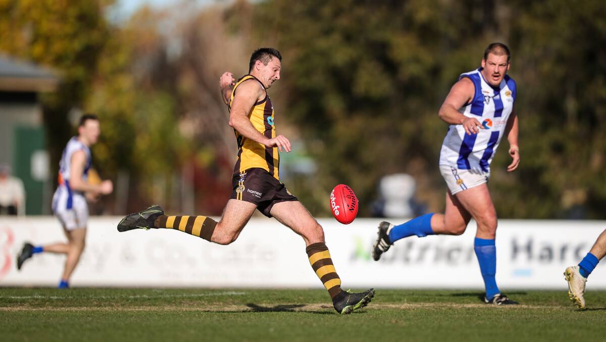 Shane Gaston gets his kick away watched by Corowa-Rutherglen's Tom Goodwin. Picture: JAMES WILTSHIRE