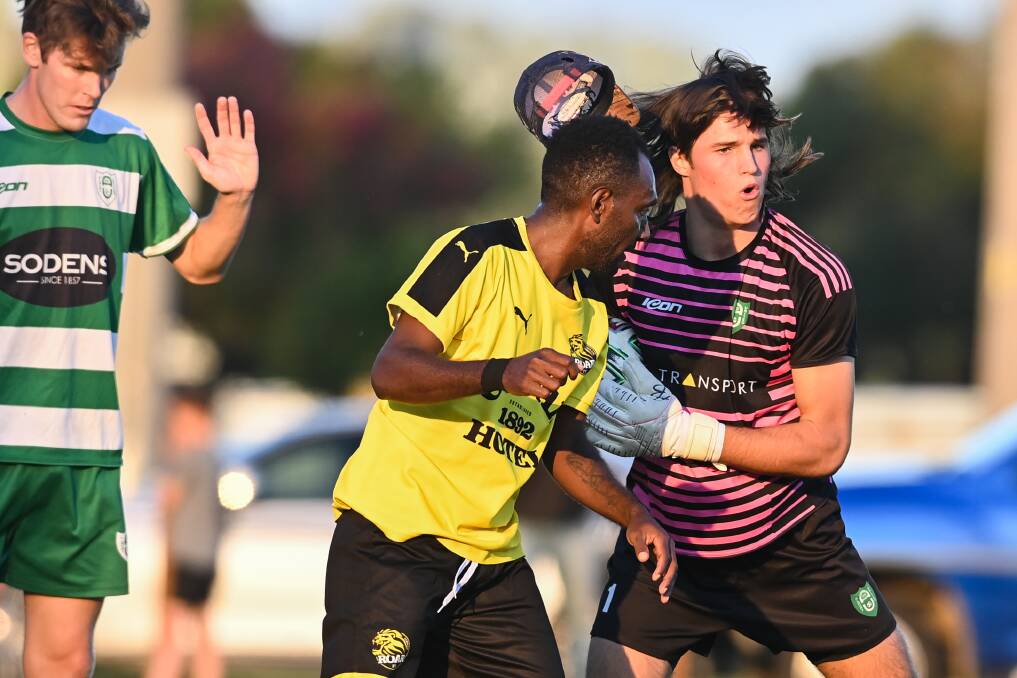 Jay Barker's cap falls off as he bumps into Jackson Temarkon. Picture: MARK JESSER