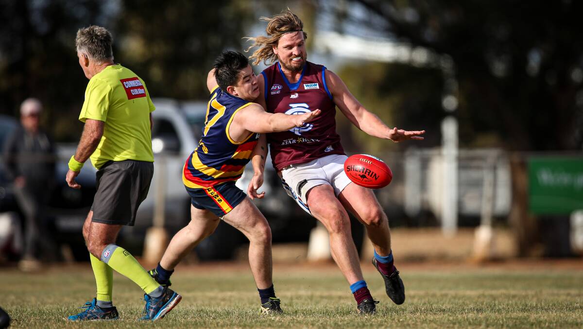 UNDER PRESSURE: Culcairn forward Adam Prior gets his kick away despite the close attentions of Billabong Crows' Mark Beale. Picture: JAMES WILTSHIRE
