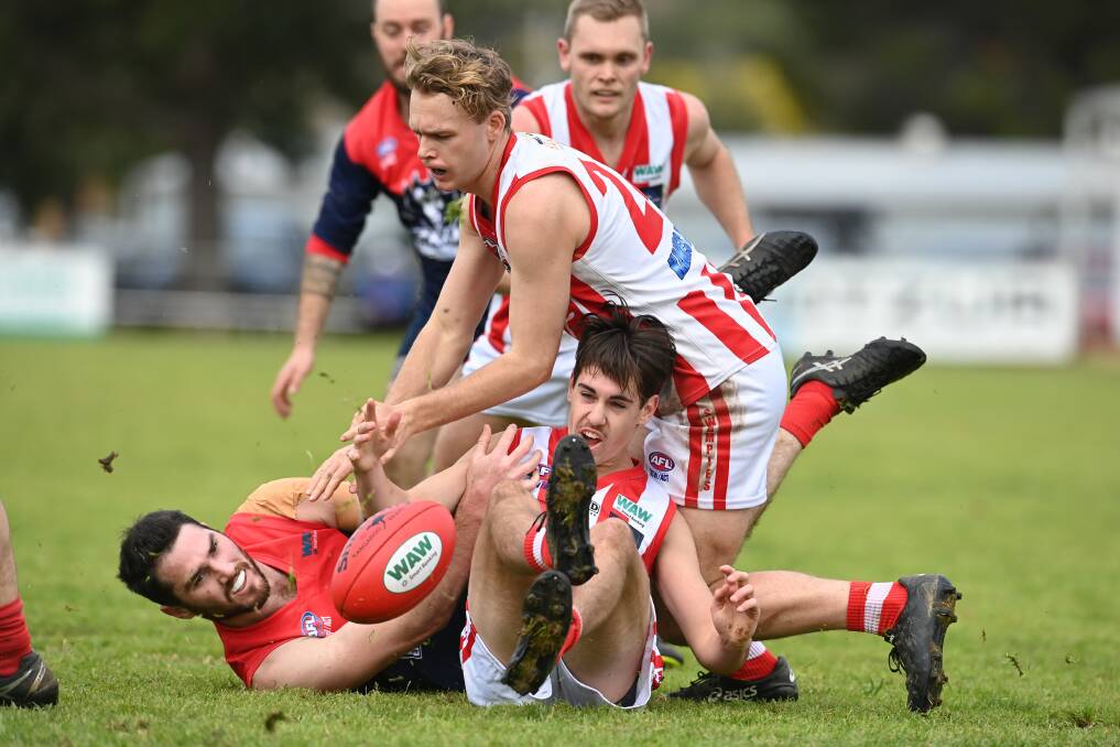 Jesse Margosis finds himself at the bottom of a pack as Henty's Charlie Doig and Benjamin Carmichael try to get their hands on the ball. Picture: MARK JESSER