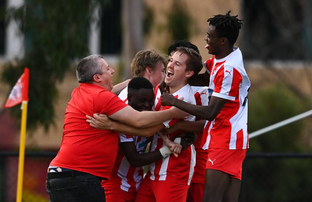 WINNER: Luke Behrends is mobbed by his Wodonga Diamonds team-mates after scoring the goal which sunk Cobram on Sunday. Incredibly, the day's five matches produced a total of 29 goals. Picture: MARK JESSER
