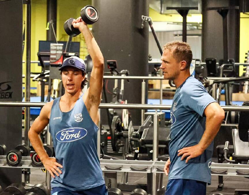 Ollie Hollands in the gym with Geelong captain Joel Selwood.