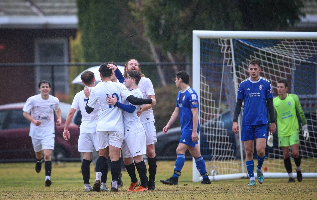 WHITE RESULT: Connor Caponecchia, second from left, is mobbed after scoring the free-kick which handed Myrtleford victory away to Albury City on Sunday. This win keeps the Savoys third. Picture: JAMES WILTSHIRE