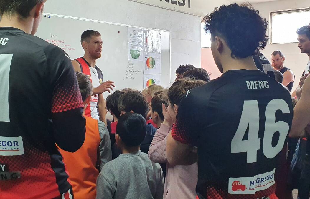 SHORT AND SHARP: Myrtleford's Auskickers join the senior footballers for a pre-match team meeting.