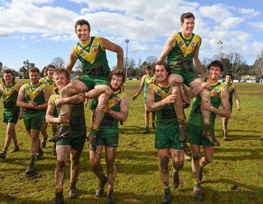 CLUB STALWARTS: Travis Jones and Nick Cottrell are chaired off the ground by their team-mates on Saturday after playing their 150th and 200th games for Holbrook respectively. Picture: MARK JESSER