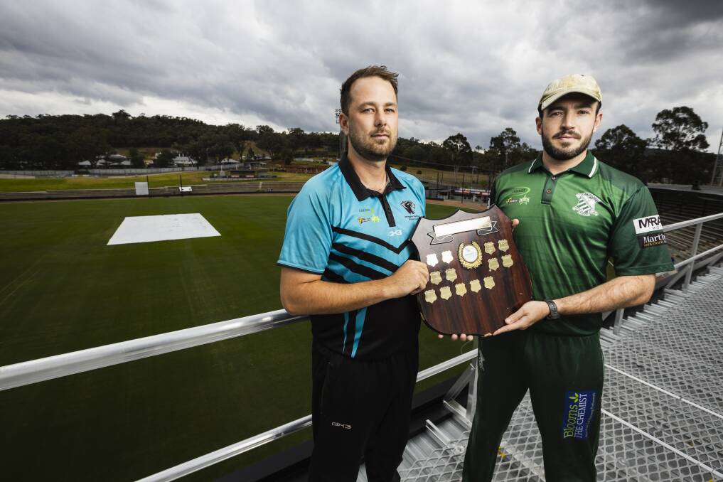 Lavington captain Dave Tassell and his St Patrick's counterpart, Dean Nicholson, with the Cricket Albury-Wodonga provincial premiership shield up on the roof at Lavington Sports Ground. Picture by Ash Smith
