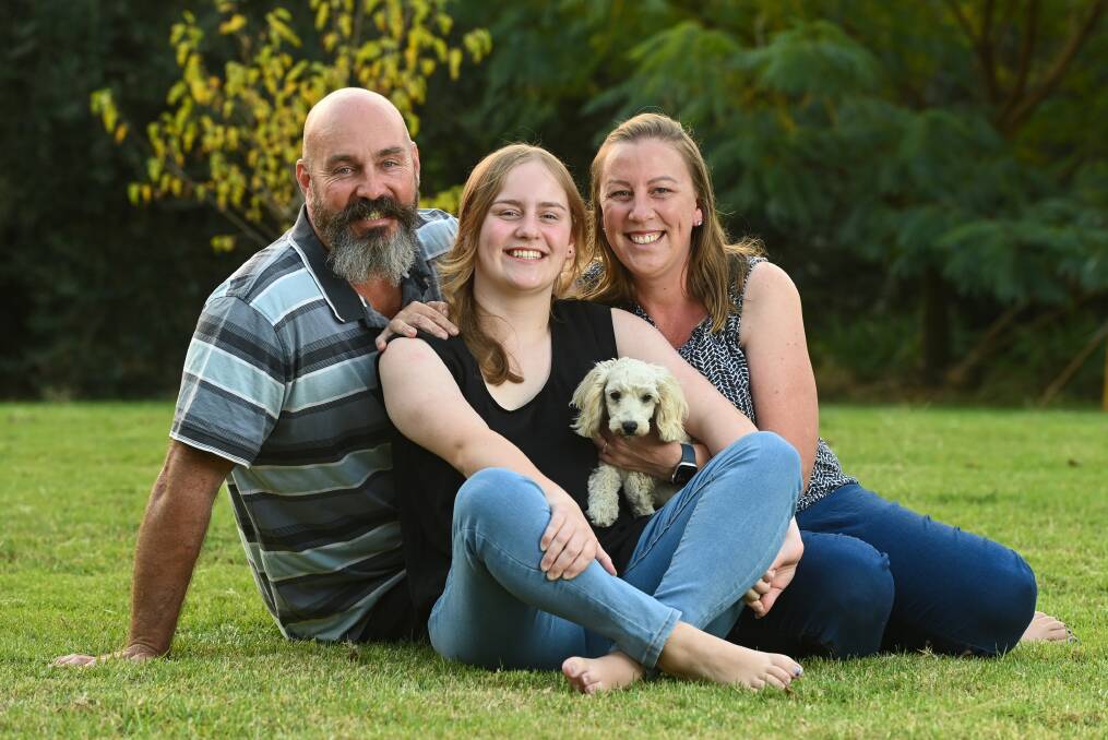 HARD JOURNEY: Matt and Kristy McMahon, with daughter Ella, 14, and family dog, Bea. Ella was diagnosed with bone cancer in her leg when she was eight-years-old. Her parents are advocating for paediatric cancer services so that children can be treated closer to home. Pictures: MARK JESSER
