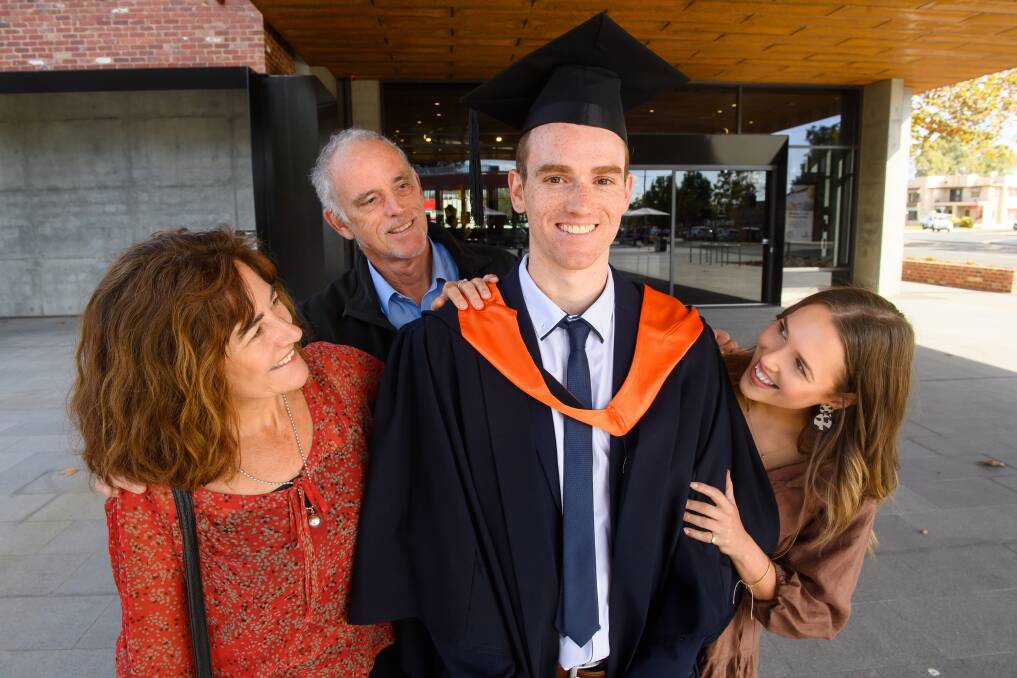 Bachelor of Business (Sports Management) graduate Jack Penny celebrates with proud mum Dione Mills, dad Peter Penny and partner Anna McGown.