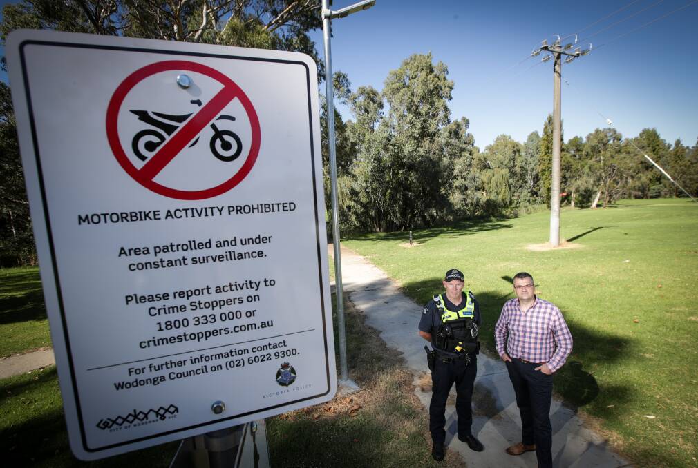 NEW SIGNAGE: Acting Sergeant Mathew Kille and Wodonga mayor Kev Poulton at Willow Park, where multiple sightings have been reported. Picture: JAMES WILTSHIRE