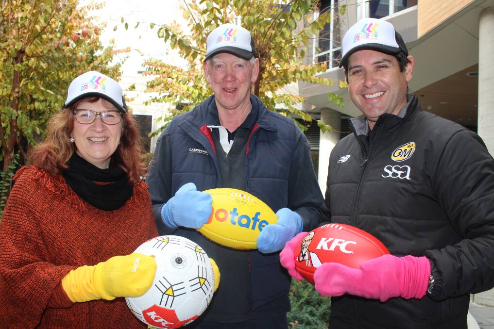 BRIGHT COLOURS: Heather and Terry Greaves, with O&M Football Netball League general manager Craig Millar, will launch Terry Socks it to Cancer. The first charity round will be played this Saturday. 