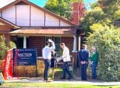 Auctioneer Jack Stean, second from left, at the auction for 525 Macauley Street on Saturday afternoon. Picture by Ted Howes