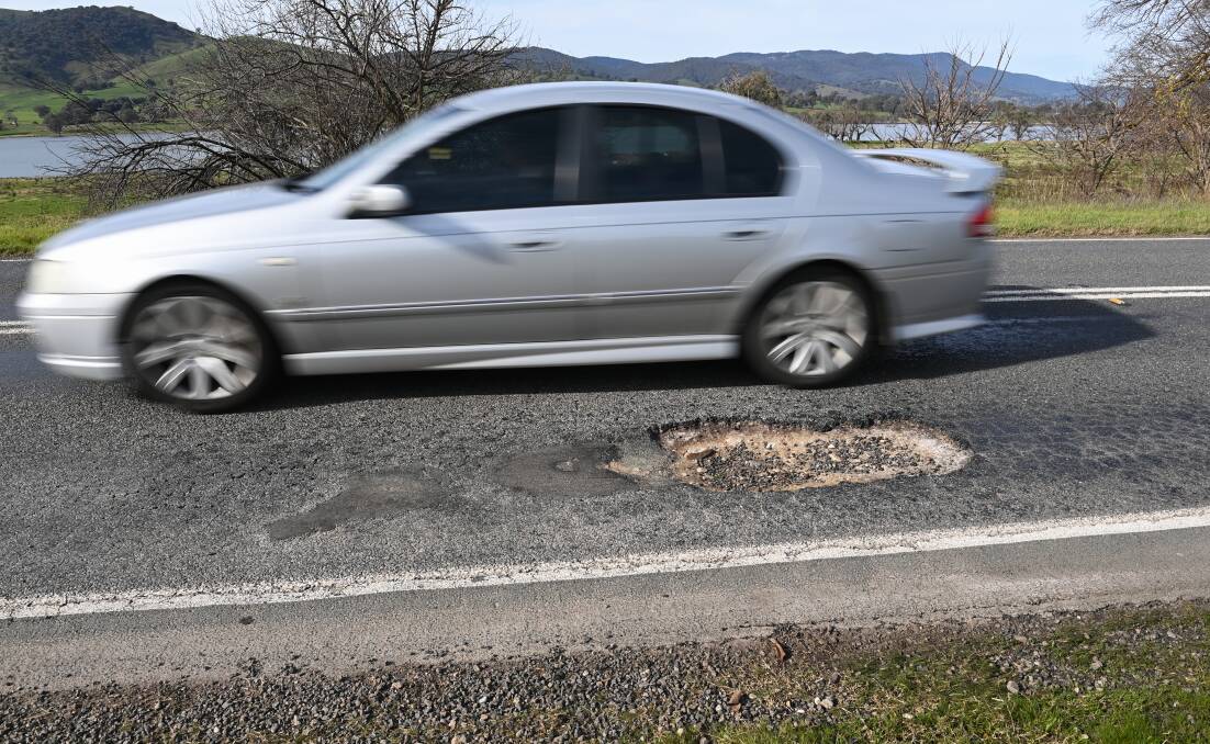 A car comes close to swerving over the double line to avoid a pothole on the Murray Valley Highway at Huon. Picture by Mark Jesser