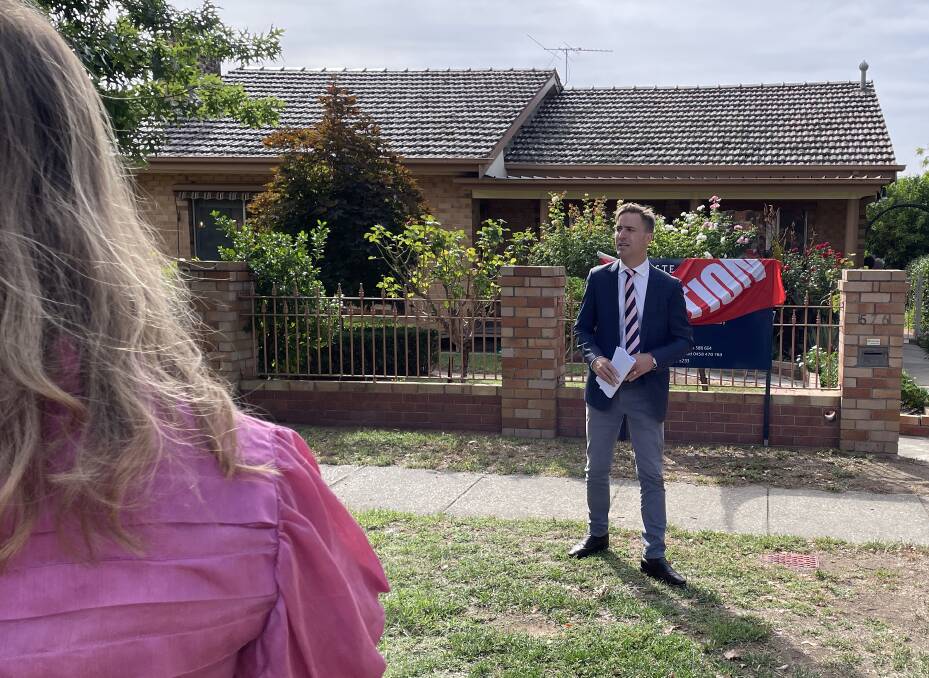 The winning bidder signals auctioneer Jack Stean, from Stean Nicholls Real Estate, during Saturday morning's auction at 576 Thurgoona Street, Albury. Picture by Ted Howes