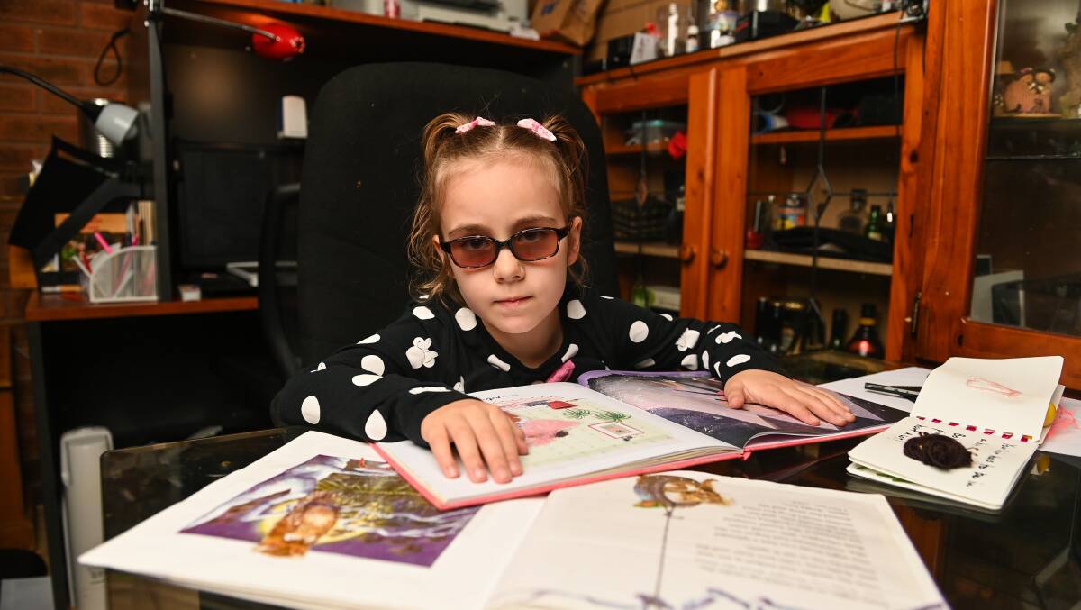 Zoe Bohun, 7, who is legally blind with her Feelix Children's Library Braille books. Picture by Mark Jesser