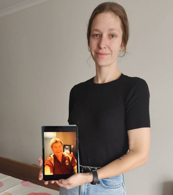 Amy Ratcliffe with her father Tim's image, has pleaded for help to retrieve her lost bracelet that contained Tim's remains.