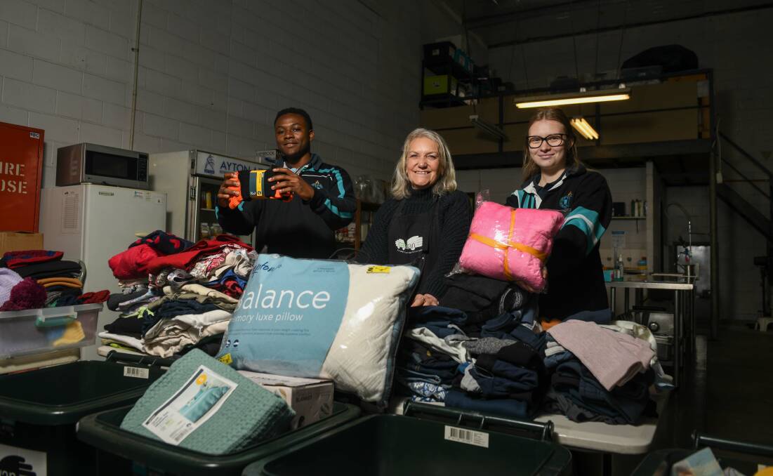 Students are providing a helping hand at this year's Winter Appeal. Pictured is Filipo Ndume, 18, Carevan project officer Leanne Johnson and Erin Leaver, 18. Picture by Tara Trewhella