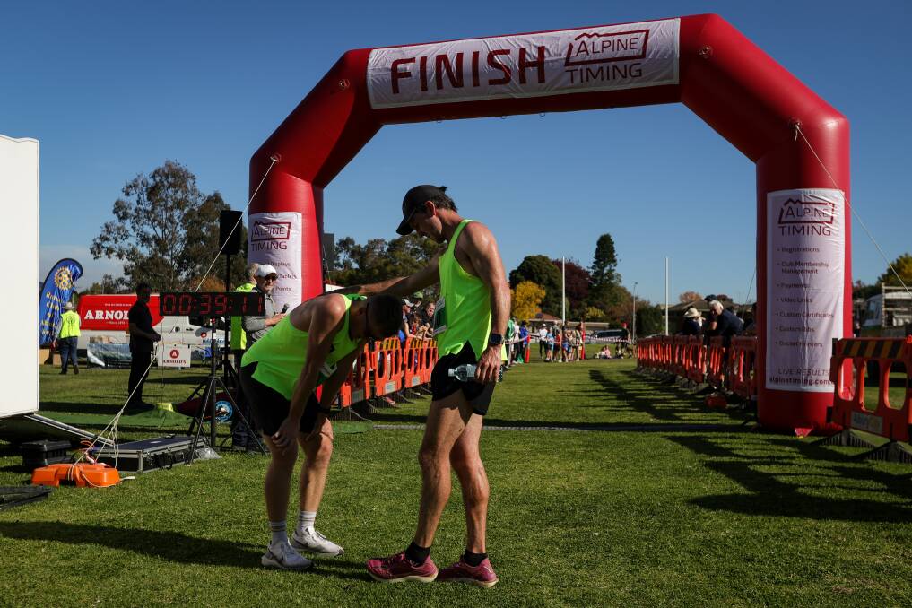 An exhausted Patrick Stow and Liam Adams congratulate each other after the 2024 Nail Can Hill Run. Picture by James Wiltshire