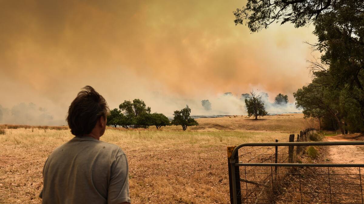 DISASTER: An onlooker peers into the distance as smoke builds. Picture: MARK JESSER