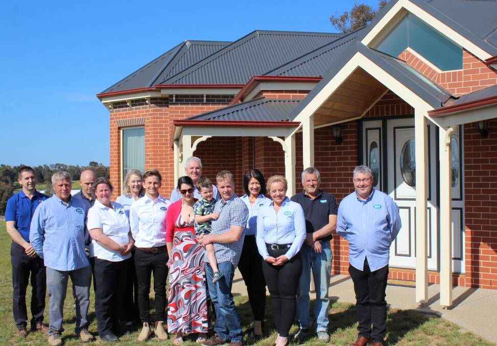 TEAM EFFORT: The Farrell family with the B&H Homes team pictured outside the award winning home.
