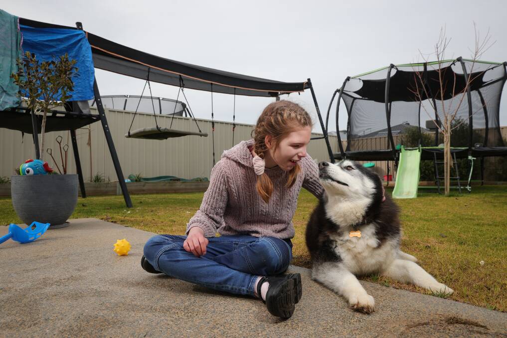 FAMILY TIES: Ella Stephens, who is non-verbal, shares a moment with family dog Lucy at home at Yarrawonga.