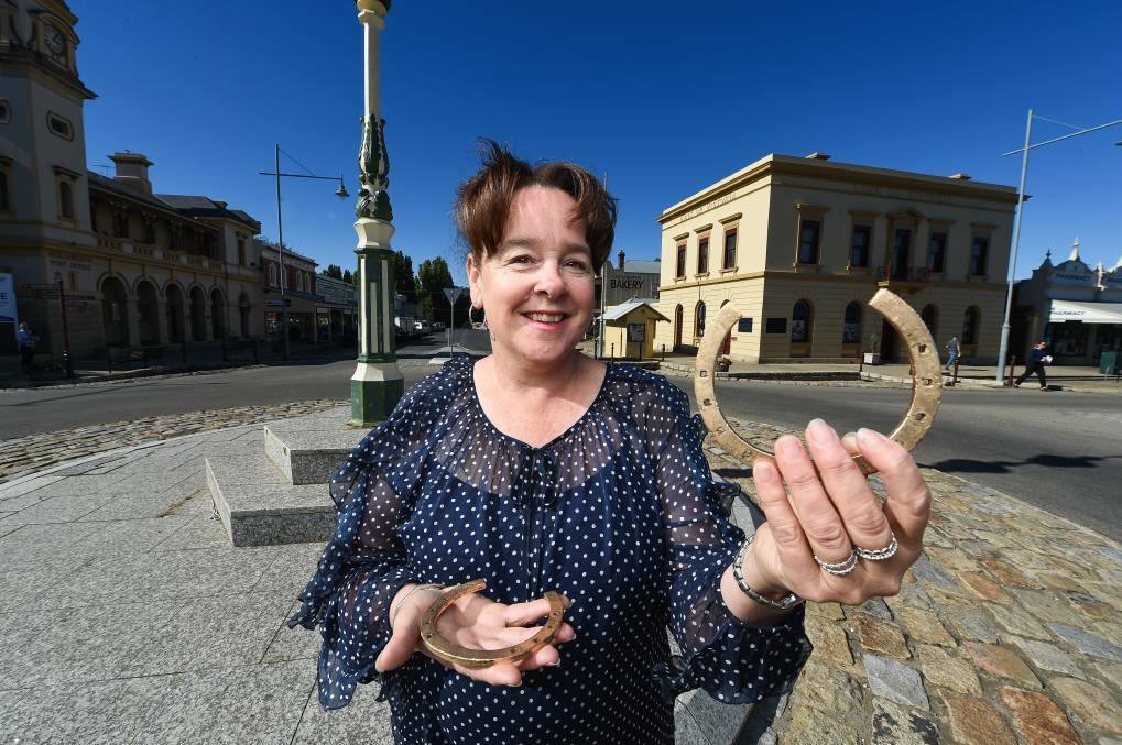 Beechworth Golden Horseshoe Festival organiser Amanda Hausler with the real-deal horseshoes, which are on display at Beechworth Gold. 