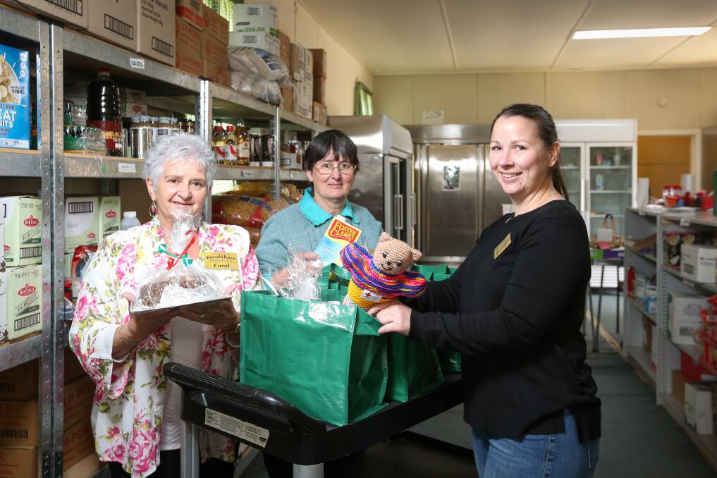 TEAM WORK: Carol Allen, Pat Spicer and Amanda Meagher pack Christmas hampers for delivery.