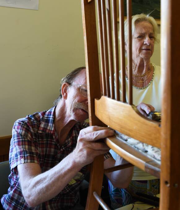 EASY FIX: Furniture and woodwork volunteer repairer Lloyd Charter fixes a chair belonging to Albury's Norma Forbes during the Repair Cafe trial. The program will become regular on the Border from June 4. Picture: MARK JESSER