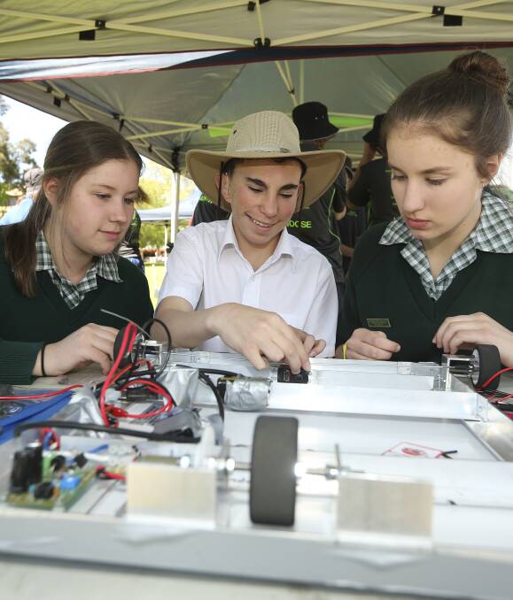 PIT STOP: Mount Carmel Christian School students Jessica Hogan, 15, Louis Wolmarans, 15, and Teagan Hogan, 14, fine-tune their entry in the Solar Car Challenge practice race day at MAMA on Friday. Picture: ELENOR TEDENBORG