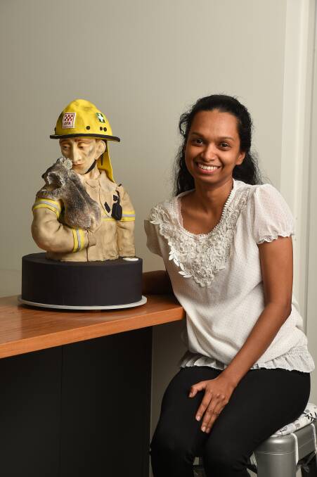 Ashini Wijayaneththi with the bust cake of a firefighter and a rescued koala, named Andy and Chiko, which will be on display at #bake4bushfires. Picture: MARK JESSER