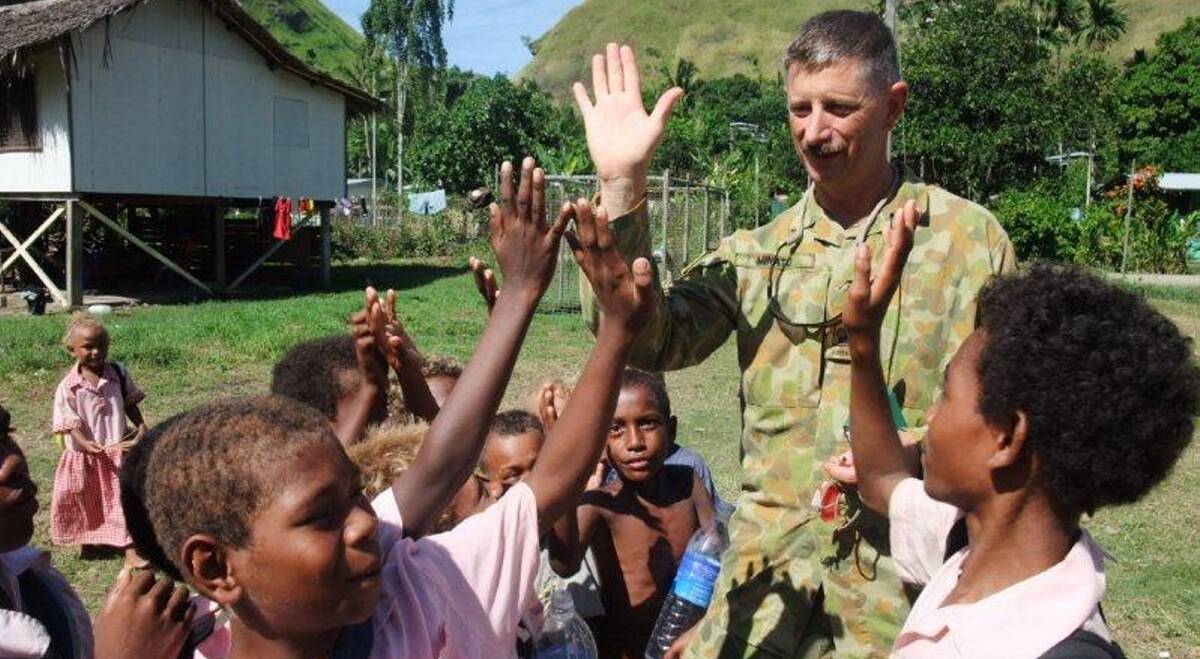 HIGH FIVE: WO2 Robert Minato farewells children at Tuvaruhu Community High School after a successful outreach patrol in the Solomon Islands.