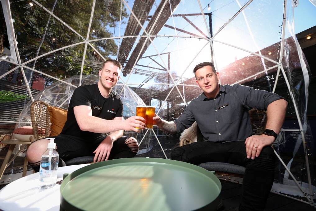 BOX SEAT: Beer Deluxe Albury's Mitch Harris and Bart Furst raise a toast in the Winter Igloo Village, which will be on site until September 10. Patrons can book igloos for eight guests for 90 minutes. Picture: JAMES WILTSHIRE
