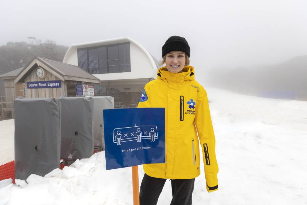 SNOW BUSINESS: Mount Buller staff member Kate Moffatt prepares for the season with signage explaining social distancing on chairlifts. Picture: JORDAN MOUNTAIN