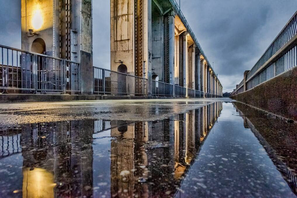 HIGHER GROUND: A reflective image, showing the upper-structure of the Hume Dam wall, from a low perspective on the pedestrian walkway. Picture: GRAHAM SLINGSBY