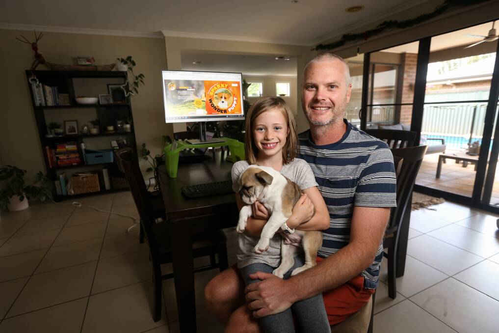 FAMILY TIES: East Albury travel writer Craig Sheather, with daughter Lyra, 7, and Rocky, has written his first children's book capturing the story of Sparky the puppy who survived the Upper Murray bushfires. Picture: JAMES WILTSHIRE