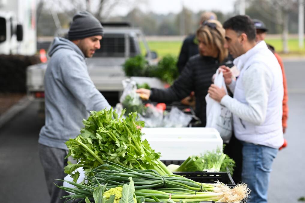Cobram producer Frank Verduci attends to a constant queue for his fresh vegetables, particularly specialty green varieties that are in low supply in supermarkets.