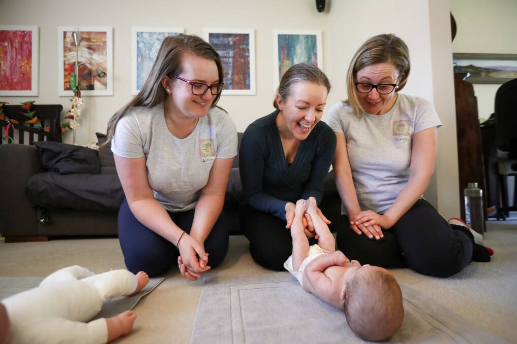 MUM'S THE WORD: Baby and Me Massage co-founders Erin Trathen and Sarah Dechert support Rebecca Meldrum (centre) to massage her baby, Sarah, 21 weeks corrected to nine weeks. Picture: JAMES WILTSHIRE