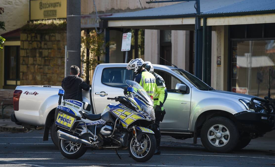 CHECKING UP: Victorian State Highway Patrol police on motorbikes stopped vehicles in Beechworth over Easter, checking where people lived and why they were travelling. Picture : MARK JESSER