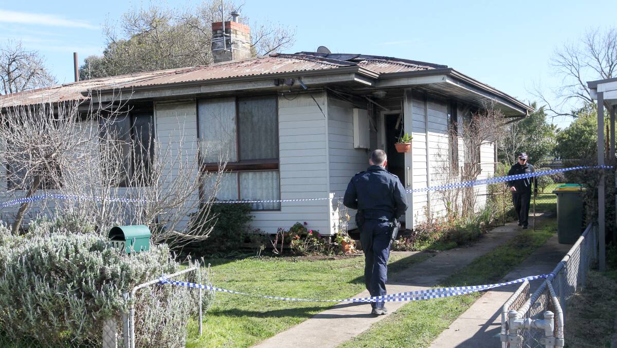 DANGEROUS FIRE: Crime scene police investigate the damaged house at a Burke Street home in Wangaratta on Friday.