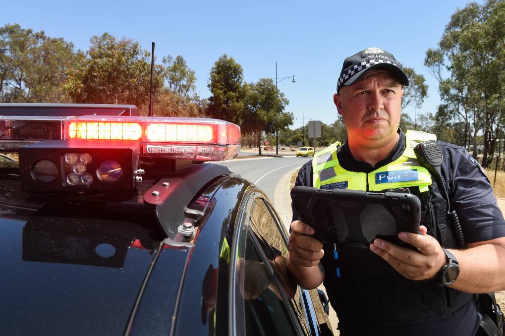 MAKING IT HARDER TO GET AWAY: Senior Constable Paul Marshall with the tablet connected to automated number plate recognition technology that will be installed on all new highway patrol vehicles. Pictures: MARK JESSER