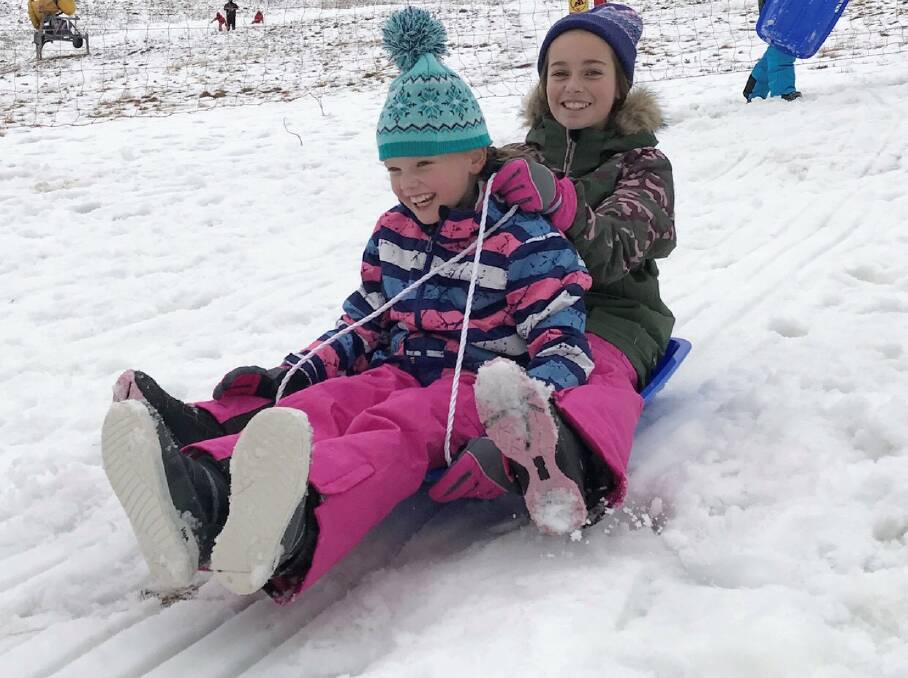 ALL SMILES: The small amount of snow which fell at Mount Hotham on Friday was enough for provide fun on toboggans. Picture: MOUNT HOTHAM MANAGEMENT BOARD