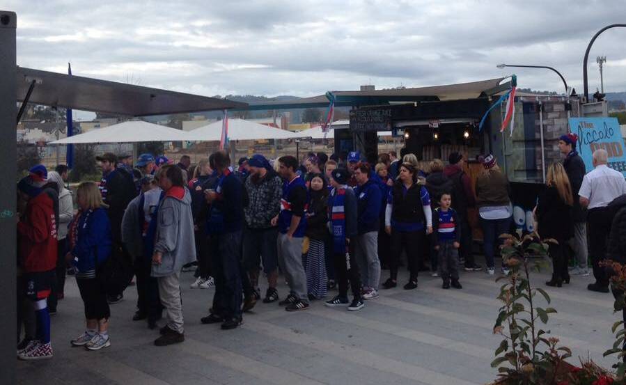 RED, WHITE AND BLUE: About 600 Western Bulldogs supporters stopped at Wodonga's Junction Place on Saturday as their bus made its way from Melbourne to Sydney.