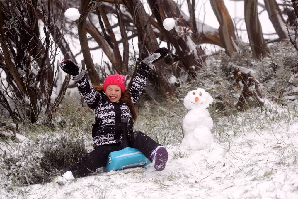AUTUMN SNOW: Ella 10, made the most of the wintry blast at Mount Hotham last month to build 2018's first snowman on the mountain. Picture: CHRIS HOCKING