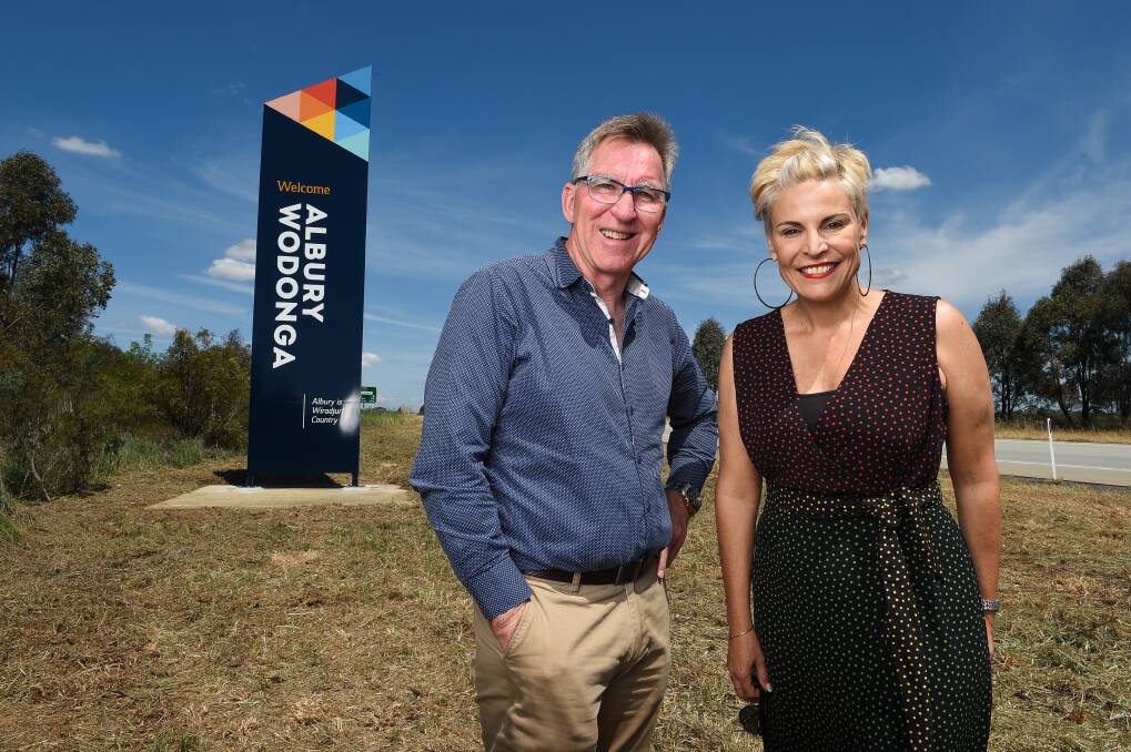 REGION BOUNDARIES: Mayors Kevin Mack and Anna Speedie with the one community sign on the Hume Highway north of Albury. Picture: MARK JESSER